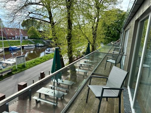 a balcony with tables and chairs on a building at Hotel Schöne Aussicht in Wilhelmshaven