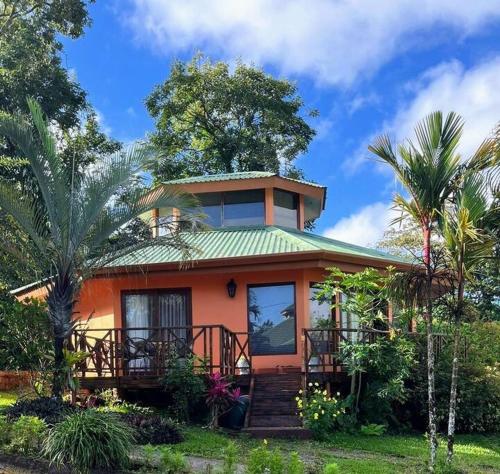 a small orange house with a green roof at Beautiful 3BR Lakeshore House in Gated Community in Tilarán