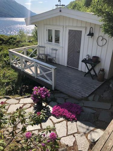 a small white house with flowers in front of it at PARADISET - a beautiful pearl 1,45 minutes from Trondheim in Surnadal