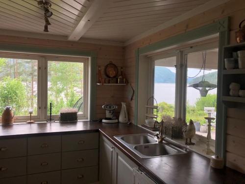 a kitchen with a sink and a large window at PARADISET - a beautiful pearl 1,45 minutes from Trondheim in Surnadal