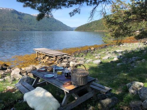 a picnic table with food on it next to a lake at PARADISET - a beautiful pearl 1,45 minutes from Trondheim in Surnadal