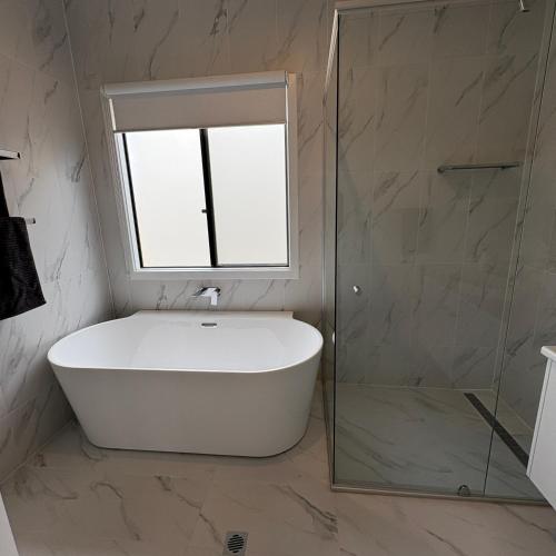a bathroom with a bath tub and a window at Goolwa Beach Pavilion in Goolwa South