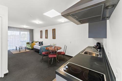a kitchen and living room with a table and a couch at Greens Motel in Nelson