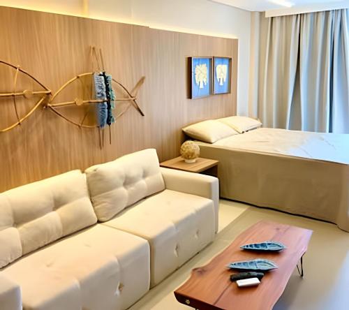a living room with a couch and a bed at Amura - Beira mar de Carneiros in Tamandaré