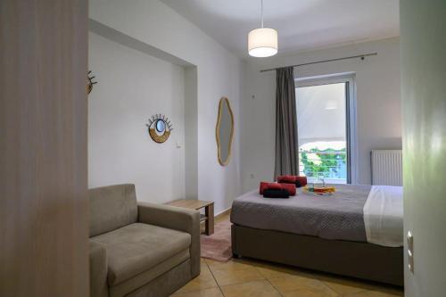 a bedroom with a bed and a couch and a window at Premium Athenian District Urban 1 bedroom flat C in Athens