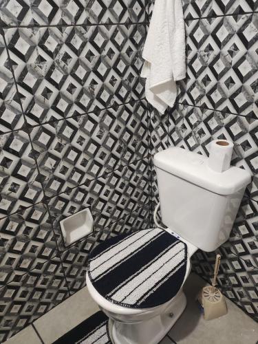 a bathroom with a toilet and a black and white patterned wall at Ginásio Adib Moysés centro de Sao Bernardo no ABC paulista in São Bernardo do Campo