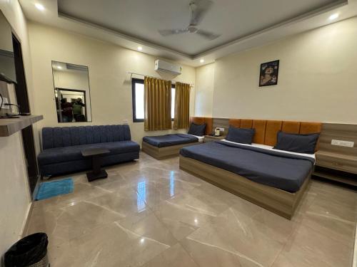 a living room with a bed and a couch and a couch at Hotel Shiv Inn By Hotelist in Haridwār