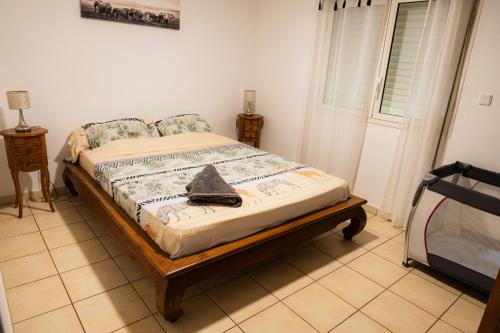 a bedroom with a bed with a cross on it at La case à Nath - Piscine chauffée et jacuzzi in Saint-Pierre