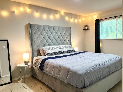 a bedroom with a bed with lights on the wall at KING SUITE 2BR Home w FAST WiFi, & WFH Desk in San Antonio