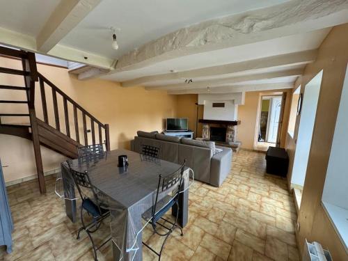 un salon avec une table et un canapé dans l'établissement Maison de campagne près du lac, à Saint-Gelven