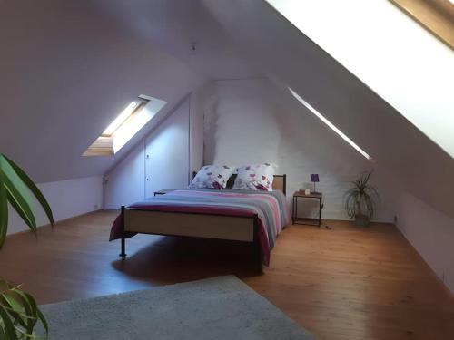 ein Schlafzimmer mit einem Bett auf einem Dachboden in der Unterkunft Maison de campagne près du lac in Saint-Gelven