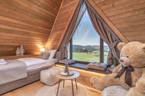 a bedroom with a large teddy bear next to a window at Forest Hill in Ravna Gora