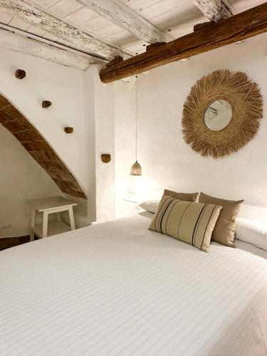 una camera da letto con un letto e uno specchio sul muro di Casa Blava, Casco Antiguo de Peñíscola a Peñíscola