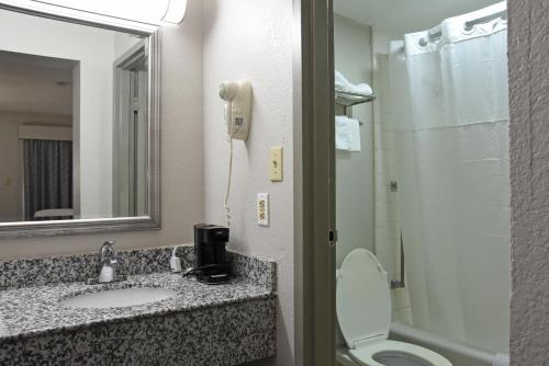 a bathroom with a sink and a toilet and a mirror at Days Inn by Wyndham Lebanon in Lebanon