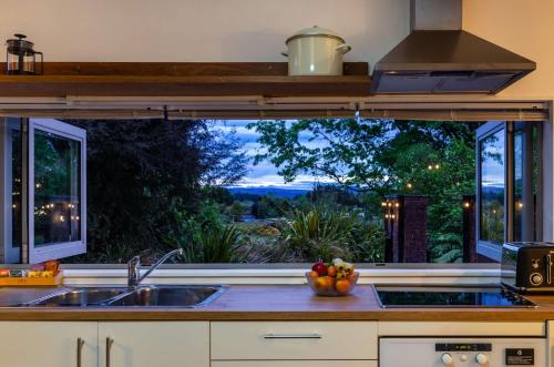 a kitchen with a sink and a large window at The Grove Turangi in Turangi