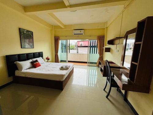 a bedroom with a bed and a desk in it at SERISIAM Apartments in Hat Yai
