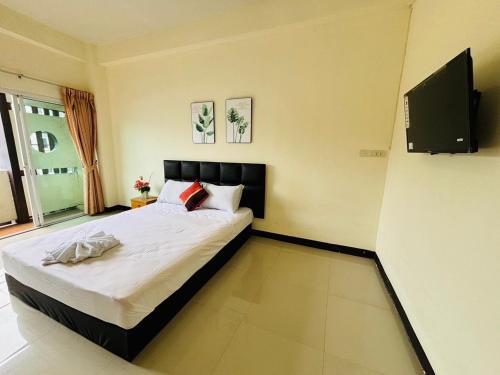 a bedroom with a bed and a flat screen tv at SERISIAM Apartments in Hat Yai