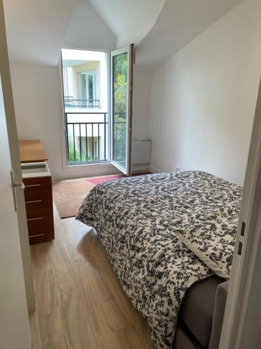 une chambre avec un lit et une grande fenêtre dans l'établissement TM Appartement BASTILLE, à Paris