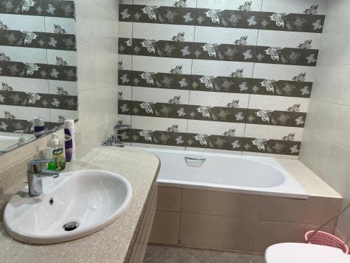 a bathroom with a sink and a bath tub at Ajman Luxurious Holiday Homes in Ajman 