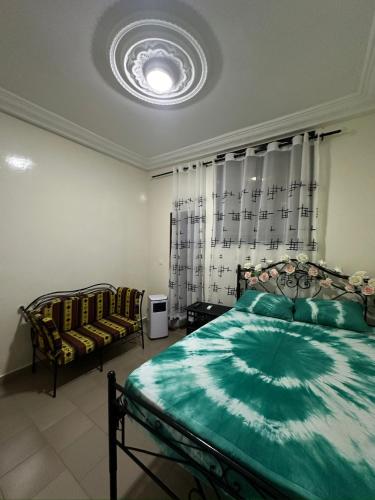 een slaapkamer met een bed met een groen dekbed bij Noflay in Dakar