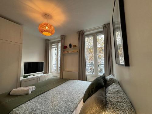 une chambre avec un lit, une télévision et une fenêtre dans l'établissement Clichy studio Getaway - C70, à Paris