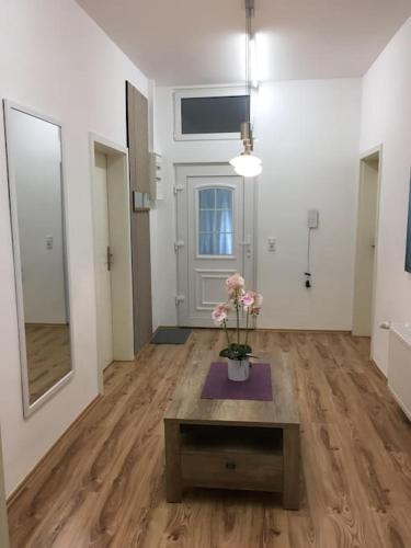 a room with a table and flowers on a wooden floor at Wunderschöne Altbauwohnung in Löhne