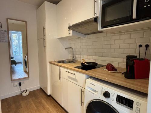une cuisine avec un évier et une machine à laver dans l'établissement Clichy studio Getaway - C70, à Paris
