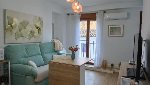 a living room with a green couch and a table at La casita de los mandalas in Cazorla