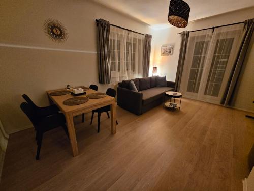 a living room with a table and a couch at Apartmán Buky 2 s krytou terasou a grillem in Mladé Buky