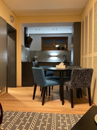 a kitchen and dining room with a table and chairs at Apartmán u lesa Nové Jirny in Nové Jirny