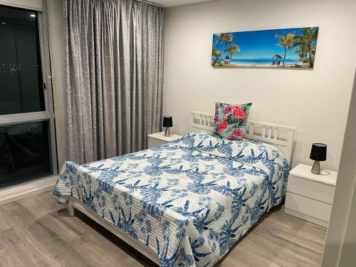 a bedroom with a bed with a blue and white comforter at Marina ocean view at Shores Southport in Gold Coast