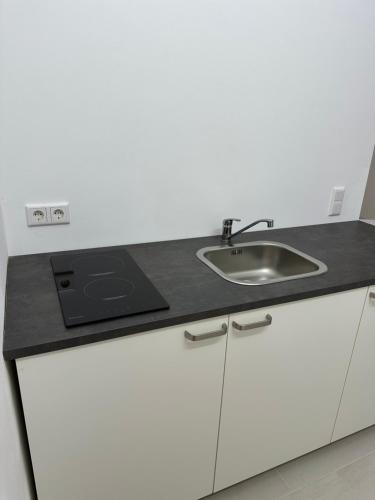 a kitchen with a sink and a counter top at Apartment-Checkin-Düsseldorf in Düsseldorf