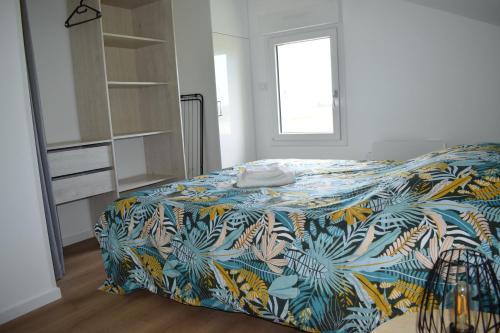 - une chambre avec un lit et une couverture colorée dans l'établissement Gîte de la Chicorée, à Saint-Folquin