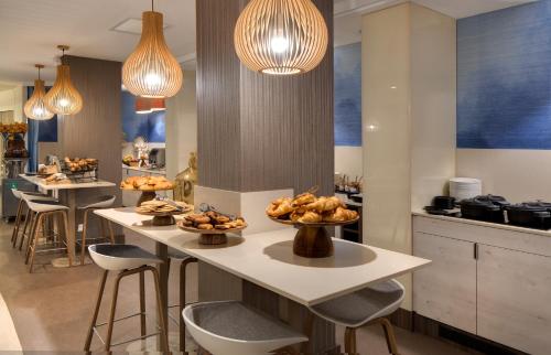 a kitchen with a counter with bowls of food on it at Mercure Montpellier Centre Comédie in Montpellier