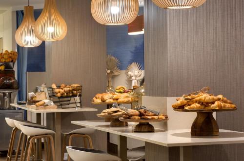 a bakery with many different types of pastries on tables at Mercure Montpellier Centre Comédie in Montpellier
