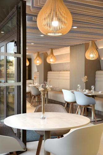 a dining room with a table and chairs at Mercure Montpellier Centre Comédie in Montpellier