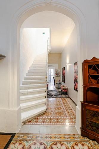 a hallway with white stairs and a rug at "Spirit of Malta" Historic Maltese Townhouse by the sea in Sliema