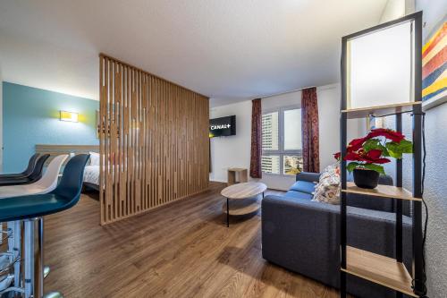 une chambre d'hôtel avec un canapé et un lit dans l'établissement Serenity Aparthotel, la Défense - Eiffel tower view - 5 min walk to Subway, à Courbevoie