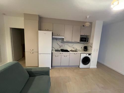 un salon avec un canapé et une cuisine dans l'établissement Appartement rez-de-chaussée, à Lit-et-Mixe