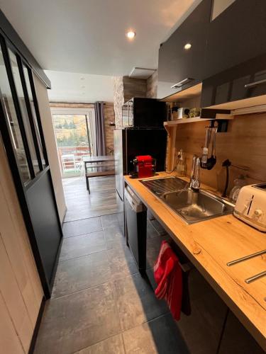 une cuisine avec un évier et un plan de travail dans l'établissement Appartement au cœur des 2 Alpes, à Les Deux Alpes