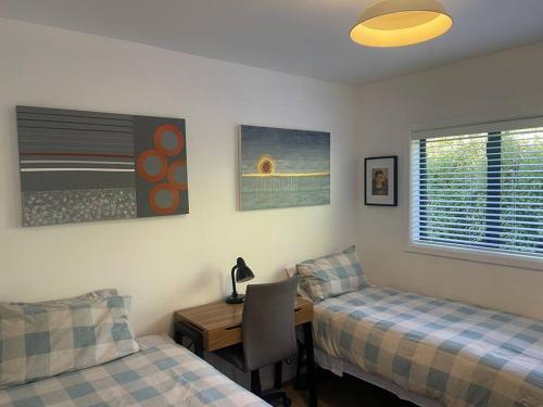 ein Schlafzimmer mit zwei Betten und einem Schreibtisch und einem Tisch in der Unterkunft Marine Bach - Diamond Harbour in Diamond Harbour