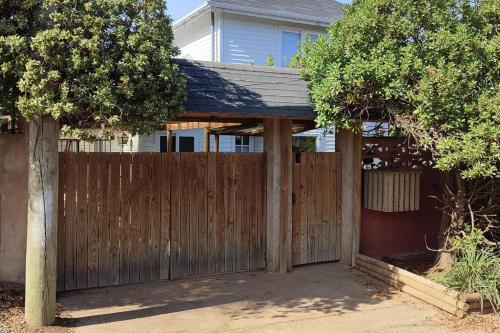 a wooden fence in front of a house at Linda cabaña en duplex cerca de la playa de Maitencillo in Maitencillo