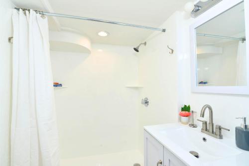 a white bathroom with a sink and a mirror at Jennifer's College Hill Apartment Private Entry & Patio in Providence
