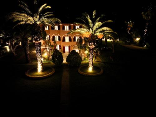 two palm trees in front of a building at night at Villa Pami in Almiros Beach