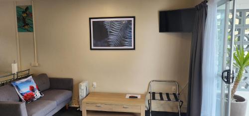 a living room with a couch and a table at Anchorage Motel in Whitianga
