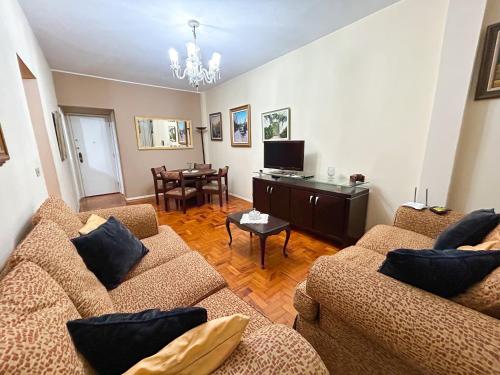 a living room with two couches and a dining room at Apartamento 2 quartos no Centro de Terê in Teresópolis