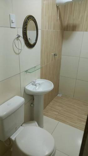 a bathroom with a toilet and a sink and a mirror at Recanto de Piranhas de Baixo in Piranhas