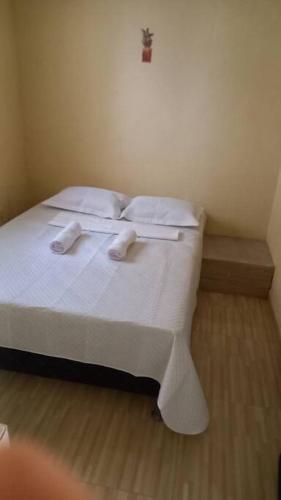 a bedroom with a bed with white sheets and pillows at Recanto de Piranhas de Baixo in Piranhas