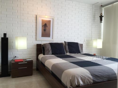 a bedroom with a bed and a white brick wall at Apto 501 E Alto del Fonce in San Gil