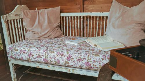 a bed with two pillows and a book on it at La Serra Sognante, casa vacanze con giardino privato tra Firenze e Fiesole in Florence